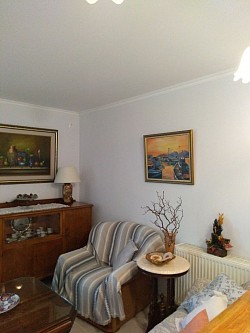 Living room with kitchen . There are sofa, armchair, wood table, TV,
